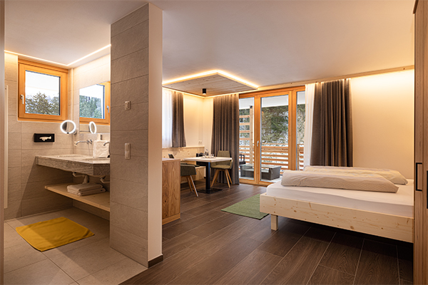 Wohnen - Unsere Zimmer & Suiten - Zimmer mit zwei Stühlen & TV - Hotel Restaurant Waldheim