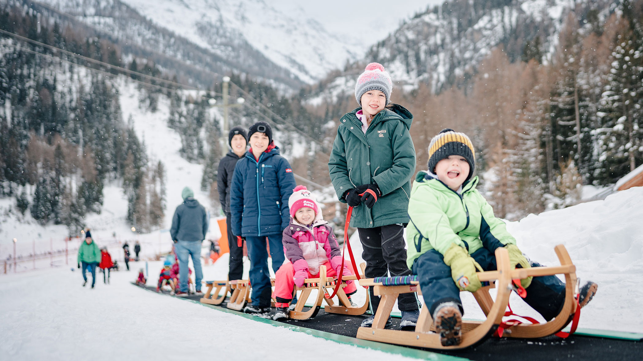 Familien mit Kinder beim Rodeln